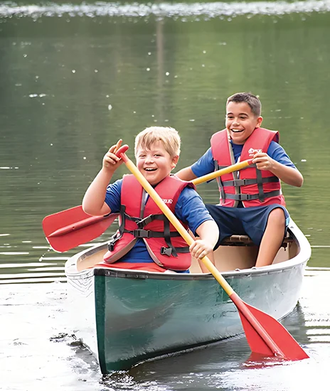 two boys at camp in a canoe