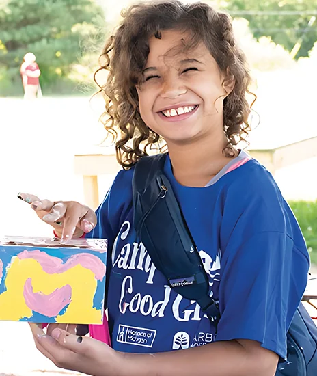 Young girl smiling while holding art project
